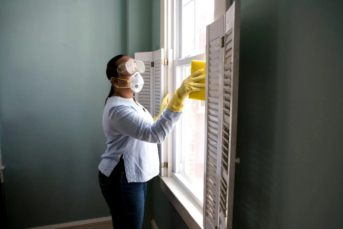 Professional house cleaner working at a window