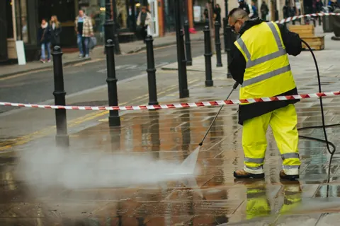 Worker using a pressure washer