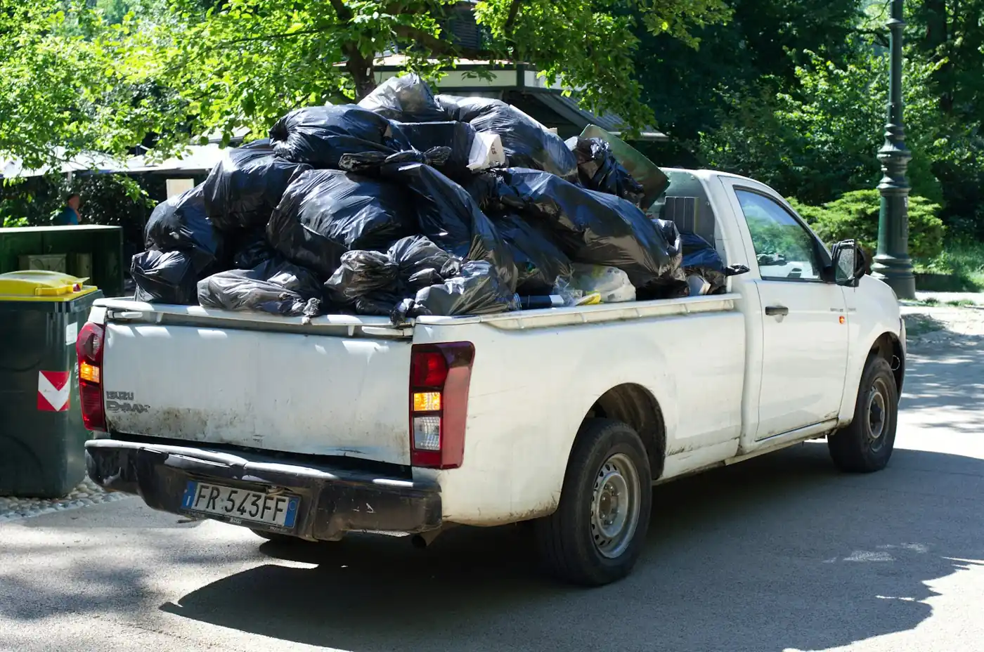 A pickup truck bed loaded with bagged junk ready for haul-away